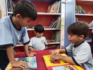 Anak-anak serius memilih dan membaca buku